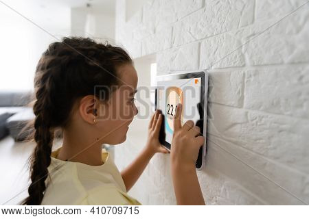 Shot Of Little Girl Using A Domotic System With Her Digital Tablet While Standing At Home.