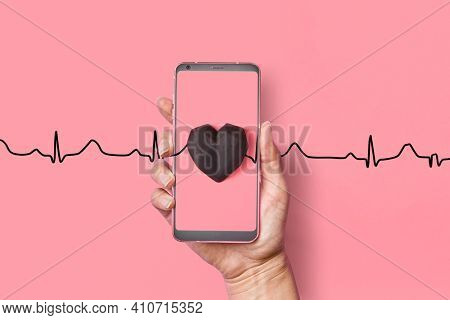Congratulation card with gypsum hearts black color on a line of echocardiogram love line on a pastel pink background, copy space. Valentine's day greeting card.