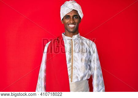 Handsome indian man wearing tradition sherwani saree clothes with a happy and cool smile on face. lucky person. 