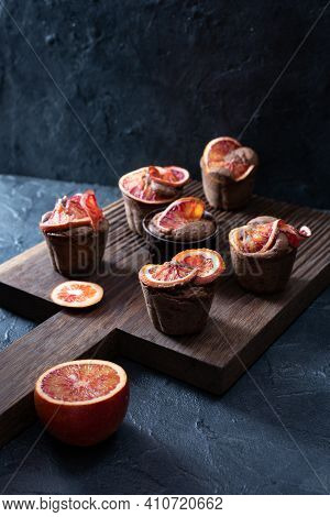 Blood Oranges Brownie Muffins On Dark Oak Cutboard And Dark Plaster Background Copyspace