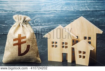 Turkish Lira Money Bag And Figurines Of Residential Buildings. Financing Urban Development And Infra