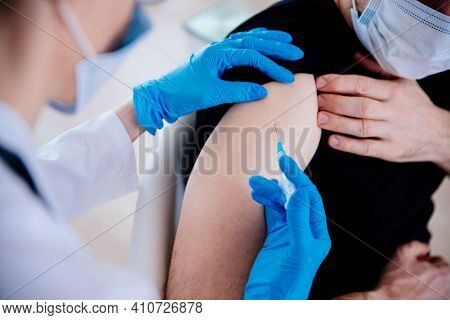 Covid-19 Or Coronavirus Vaccine.doctor Injecting Vaccination In Arm Of Man Patien.