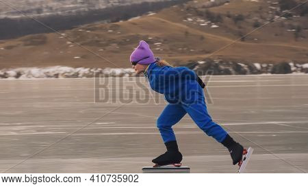 The Child Train On Ice Professional Speed Skating. The Girl Skates In The Winter In Sportswear, Spor