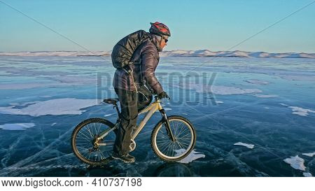 Man Is Riding Bicycle On The Ice. Ice Of Frozen Lake Baikal. Rid