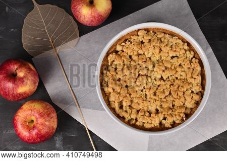 Top View Of Whole Traditional European Apple Pie With Topping Crumbles In White Springform Pan On Da