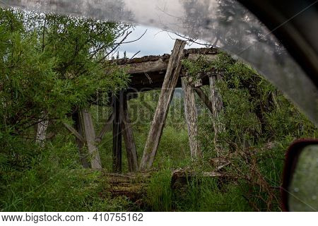 Old Destroyed Wooden Bridge On A Rainy Day. Mysterious Landscape. The Nature Of Russia In The Summer