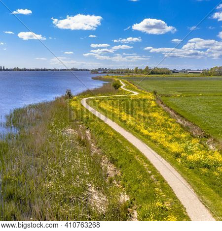 Aerial Springtime Scene Of Dutch River Near Boornzwaag. Cycling Track On Dike Meandering Throug Pold