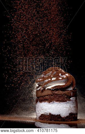 Side View Of A Fresh Baked Chocolate Cake Sprinkled With Cocoa On Countertop With Dark Background. L