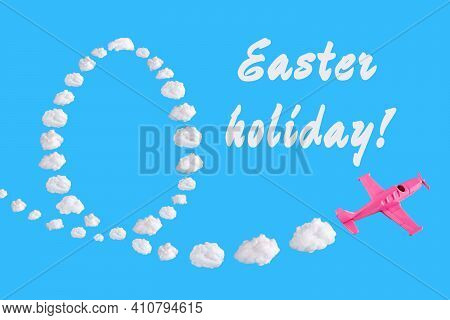 Pink Airplane Goes Into A Turn On Blue Background With Text Easter Holiday And Easter Egg Of Abstrac