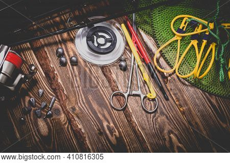Fishing Tackle On A Wooden Background. Studio Photo With Vignetting.