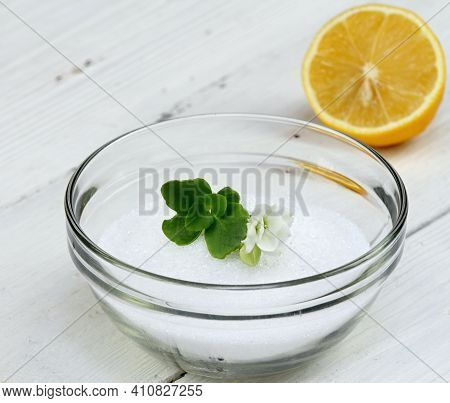 Crystalline Citric Acid In A Bowl. It Occurs Naturally In Citrus Fruit. White Wooden Table.