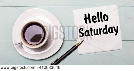 On A Light Blue Wooden Tray, There Is A White Cup Of Coffee, A Handle And A Napkin That Says Hello S
