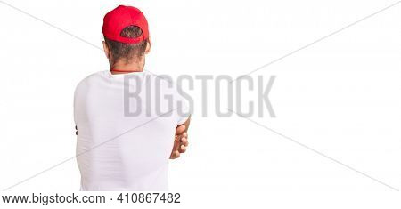 Young caucasian man wearing lifeguard t shirt holding whistle hugging oneself happy and positive from backwards. self love and self care 