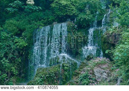 Guilin, China - May 11, 2010: Seven Star Park. Tall Waterfall With Mulitple White Water Streams Over