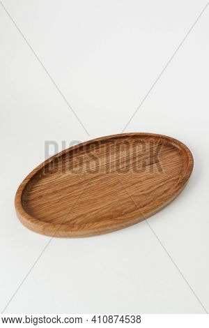 Wooden Plate With An Oval Shape On A White Background. Wooden Utensils On White Background.