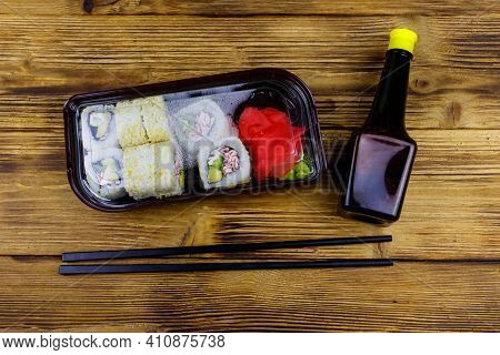 Uramaki Sushi Rolls With Surimi In Plastic Box On Wooden Table. Top View. Sushi For Take Away Or Del