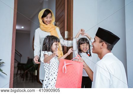 Muslim Father Giving A Gift To His Children On Eid Mubarak