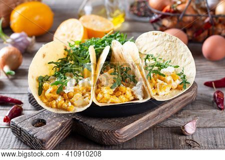 Fresh Scrambled Eggs With Crispy Tortillas, Cheese, Herbs And Vegetable On A Cutting Board On A Wood
