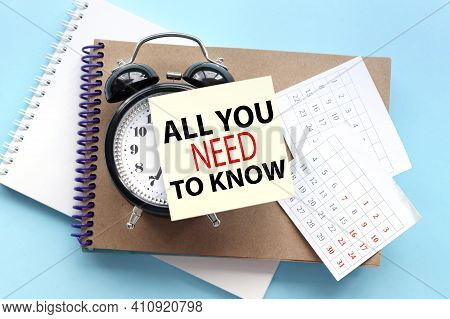 All You Need To Know. Text On The Sticker Attached To The Alarm Clock. Alarm Clock On Notepad On Blu
