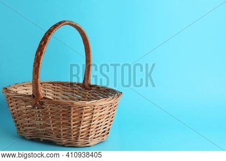 Empty Wicker Basket On Light Blue Background, Space For Text. Easter Item