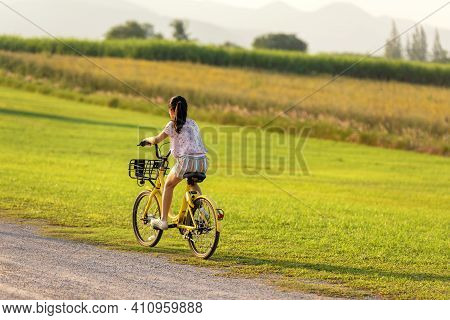 Family Happy.  Asia Gird Happy And Relax Outdoor With Bicycling At The Garden Meadow In Sunset.  Lif