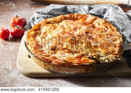 Homemade Baked Lasagna In Round Glass Baking Dish On Wooden Board