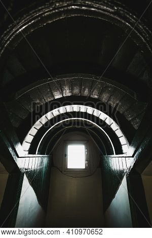A Vertical Wide-angle View Of A Dark Nook Of An Old Antique Wooden House With Arch Ceiling And A Sma