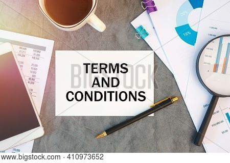 Terms And Conditions Is Written In A Document On The Office Desk With Office Accessories, Coffee, Di