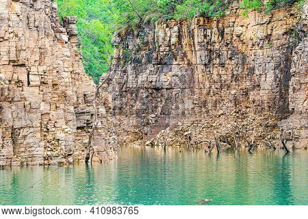 Beautiful Landscape With Sedimentary Rock Walls And Some Dry Tree Branches Out Of The Water Of The L