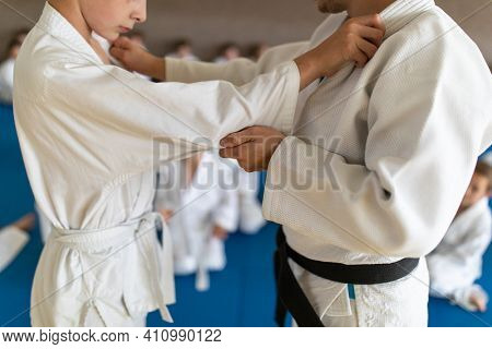Kids in a sports hall engaged in karate drill, training, practice