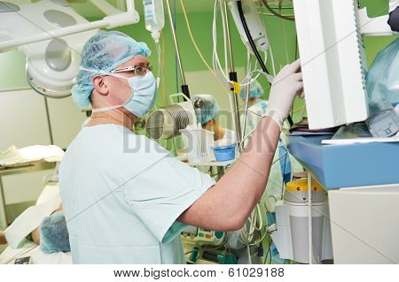 anaesthesiologist doctor in uniform preparing narcosis anaesthesia during heart transplantation operation at cardiac surgery clinic