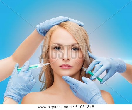 beauty and cosmetic surgery concept - woman face and beautician hands with syringes