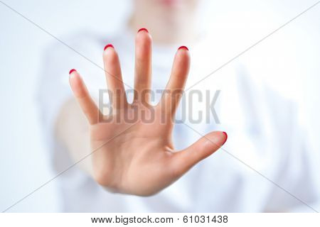 Young woman showing palm handsign.