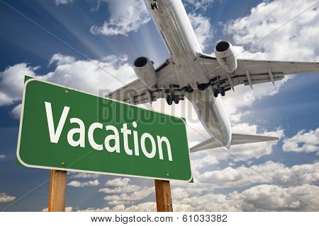 Vacation Green Road Sign and Airplane Above with Dramatic Blue Sky and Clouds.