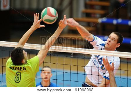 KAPOSVAR, HUNGARY - FEBRUARY 25: Tamas Vajda (white 14) in action at a Hungarian National Championship volleyball game Kaposvar (white) vs. Sumeg (green), February 25, 2014 in Kaposvar, Hungary.