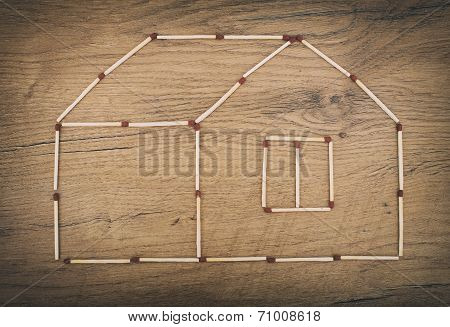 House Made From Matches On Wooden Tabletop.