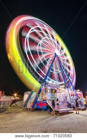 Long exposure picture of a Ferrys wheel rotating in a small local amusement park.