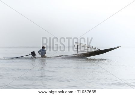 Myanmar, Shan state, Inle lake Intha fisherman on boat at early morning with fog and mist background