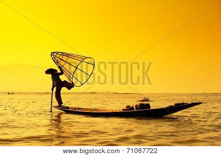 Myanmar, Shan state, Inle lake Intha fisherman on boat at amazing sunset 