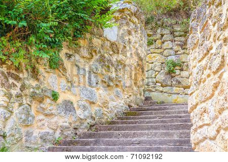Wooden Staircase Between Stone Walls.