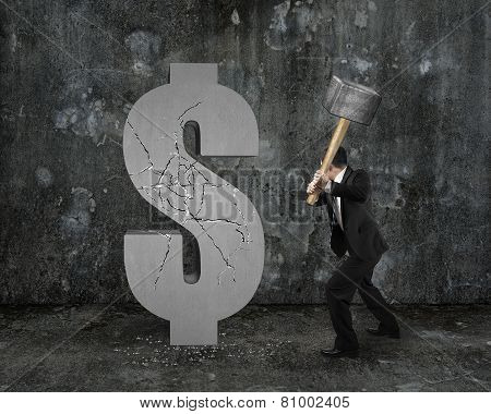 Businessman Holding Hammer Hitting Cracked Dollar Sign With Mottled Wall