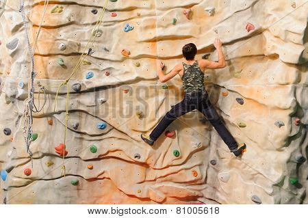 Man climbing on man-made cliff in the sport centre