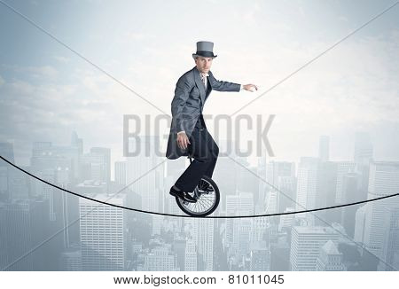 Brave guy riding a monocycle on a rope above cityscape concept