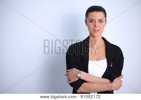 A young woman standing, isolated on graybackground