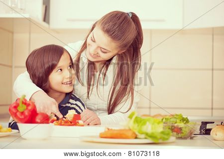 Mother and son preparing food in kitchen together
