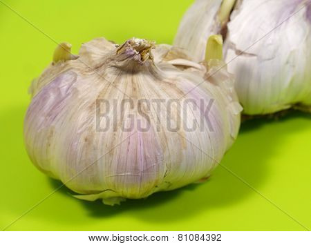 Garlic bulbs on a green cutting board