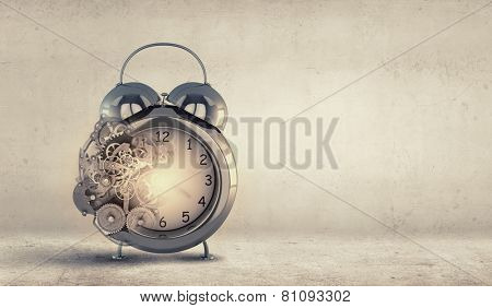 Close up of alarm clock and cogwheel mechanism