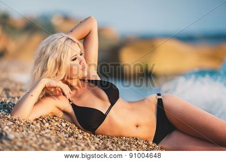 Portrait of happy sexy girls in bikini posing on the background of the sea