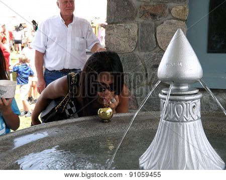 Woman Drinking at an Artesian Fountain