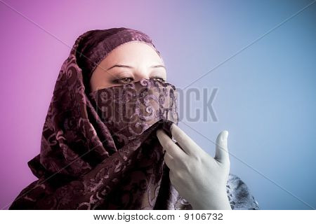 Arabiska beslöjad kvinna klädd lyser med två lampor, rosa och blått
